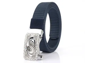 Detail of navy nylon belt featuring a silver eagle buckle with blue rhinestone eyes