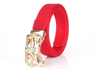 Detail of red nylon belt with golden scrollwork buckle and crystal inlay