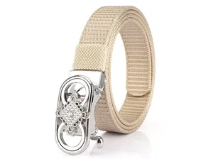 Detailed macro view of khaki nylon woven belt with crystal-studded hollow metal buckle