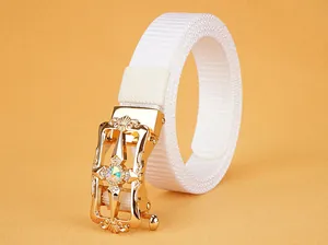 Detail of white nylon belt featuring a gold floral automatic buckle with a central rhinestone