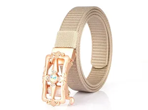 Macro detail of khaki nylon canvas belt featuring a rose gold automatic buckle with rhinestones