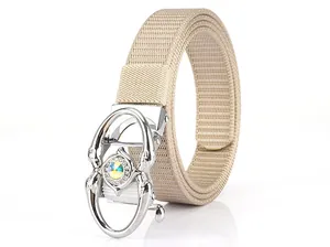 Detail of beige canvas belt with crystal encrusted silver alloy buckle on white background