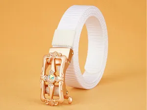 Detail of rose gold hollow buckle with iridescent rhinestone on white nylon belt