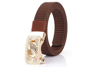 Detail of golden alloy buckle with swan relief and rhinestones on brown nylon belt