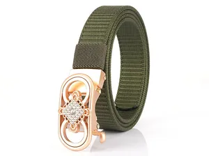 Close-up of rose gold buckle with rhinestone floral pattern on green nylon belt