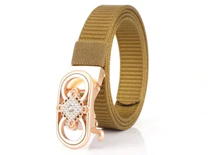 Detail of rose gold buckle with sparkling rhinestones on khaki woven nylon belt