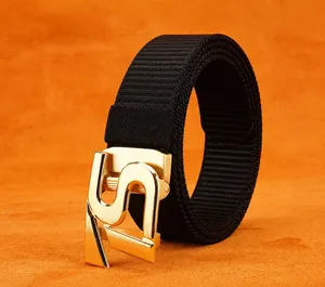 Detail of black nylon belt with a golden S-shaped automatic buckle on orange background