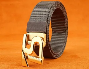 Detail of golden S-shaped metal buckle with brushed finish on grey nylon belt