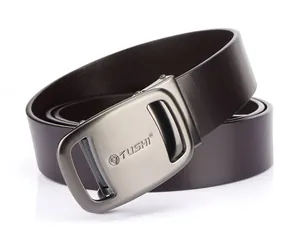 Detail of genuine brown leather belt with brushed metal buckle and engraved TUSHI logo