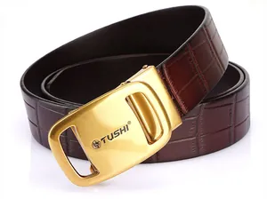 Detail of men's brown crocodile embossed leather belt with a golden TUSHI buckle