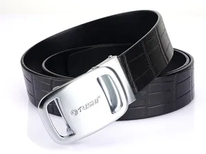 Macro detail of men's leather belt with crocodile texture and brushed silver automatic buckle