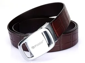 Detail of dark brown crocodile texture leather belt with silver automatic buckle and lion logo