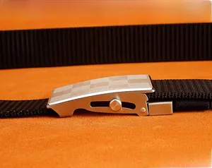 Detailed macro view of silver metal slide buckle with checkered pattern and black belt