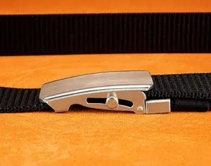 Detail of nylon belt with silver brushed automatic slider buckle and textured weave