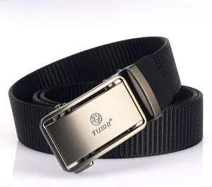Détail d'une ceinture en nylon noir avec boucle automatique en métal brossé et lion