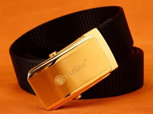 Detail view of the TUSHI gold lion buckle and black nylon woven belt on orange background