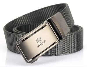 Détail de la ceinture en nylon vert armée avec boucle logo lion et texture métallique