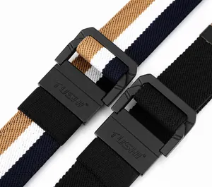 Close-up of elastic woven canvas belts with matte black double ring buckles and texture