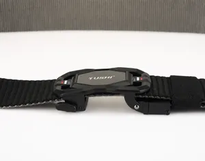 Detail of adjustable matte black buckle with TUSHI logo on durable nylon woven belt