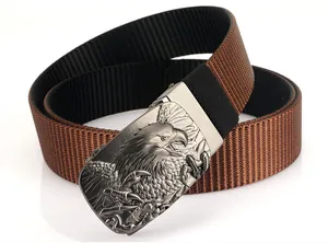 Détail d'une ceinture en nylon marron avec une boucle en métal argenté à relief d'aigle