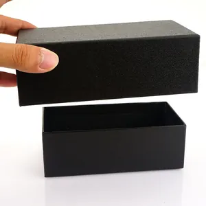 Detailed view of black textured rectangle gift box for belts with lid opening by hand