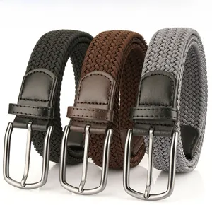 Détail de ceintures tressées en noir et marron avec boucles en métal poli