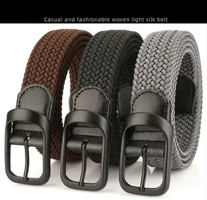 Close-up of woven stretch belts in black, brown and grey with matte metal buckles