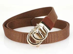 Détail d'une ceinture tressée en nylon marron avec boucle dorée et strass brillants