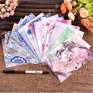 Vintage kraft envelopes with floral and landscape patterns spread on bamboo mat