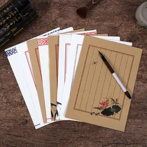 Close-up of vintage DL envelopes with traditional lotus and bamboo ink paintings on wood