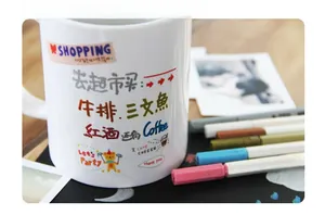 Close-up of colorful paint markers and DIY illustrations on white ceramic mug