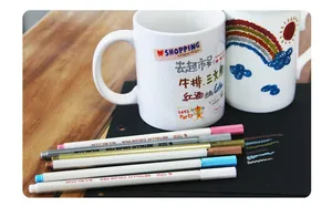 Metallic marker pens writing effect on ceramic mug and black paper with vivid colors
