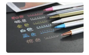 Metallic marker pens set writing effect on black card showing six vibrant glossy colors