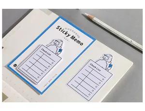 Detailed view of sticky memo checklist with cartoon girl illustration on a notebook