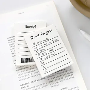 Minimalist receipt and to-do memo pad set on a book with a white pen for planning