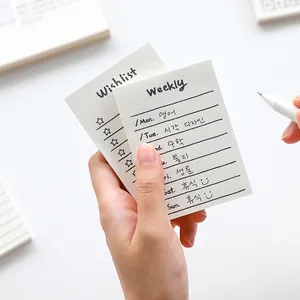Minimalist cream-colored paper notepad with weekly plan and wishlist layout for journaling