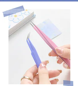 Macro shot of macaron pink straight and purple curved stainless steel tweezers for DIY