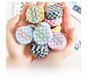 Nahaufnahme von buntem Schachbrett-Washi-Tape in den Händen für DIY-Journaling-Zubehör