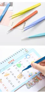 Macro detail of colorful stainless steel tweezers for precision scrapbooking and DIY stickers