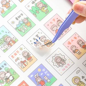 Pastel stainless steel tweezers picking up cute holiday themed cartoon stickers for journaling