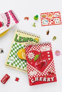 Detalle de cuadernos de espiral retro con diseños de frutas como limón y cereza