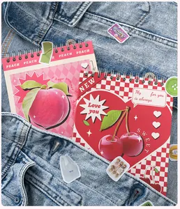 Nahaufnahme der Frucht-Spiralnotizbücher mit Pfirsich- und Kirschmotiven in der Tasche