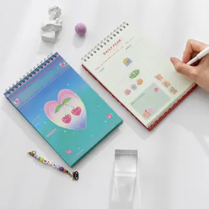 Detalle de la agenda diaria estilo Y2K con diseño interior y accesorio de amuleto