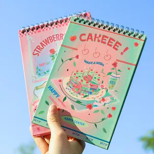 Spiralgebundener Planer-Set mit Erdbeer- und Kuchen-Illustrationen vor blauem Himmel