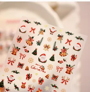 Detail of Christmas nail stickers with Santa, reindeer, and golden bells on warm background