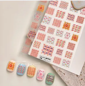 Detailansicht der 3D-Prägung Strickmuster-Nagelaufkleber mit Karo- und Blumendesigns