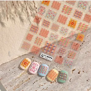 Makroaufnahme von 3D-Präge-Nagelstickern mit Vintage-Strickmuster und Karodesign