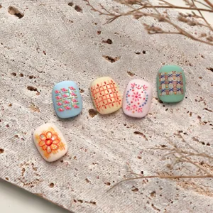 Gestrickte Karo-Nagelaufkleber mit Vintage-Stickmustern in pastellfarbenen Designs