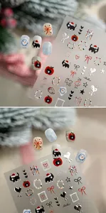 Makro-Details von Weihnachts-Nagelstickern mit schwarzen Katzen, Schneemännern und Äpfeln