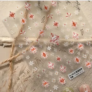 Macro detail of Christmas 3D embossed nail art stickers featuring snowman and fox patterns